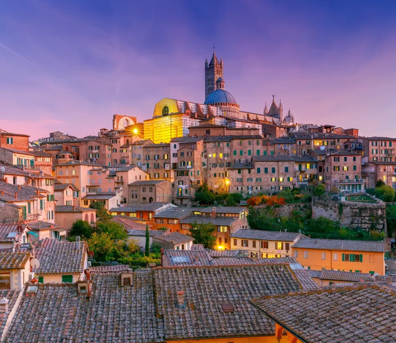 Siena met de toren van de Dom bij zonsondergang