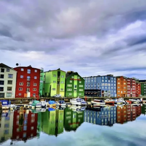 Kleurige pakhuizen weerspiegeld in de haven van Trondheim