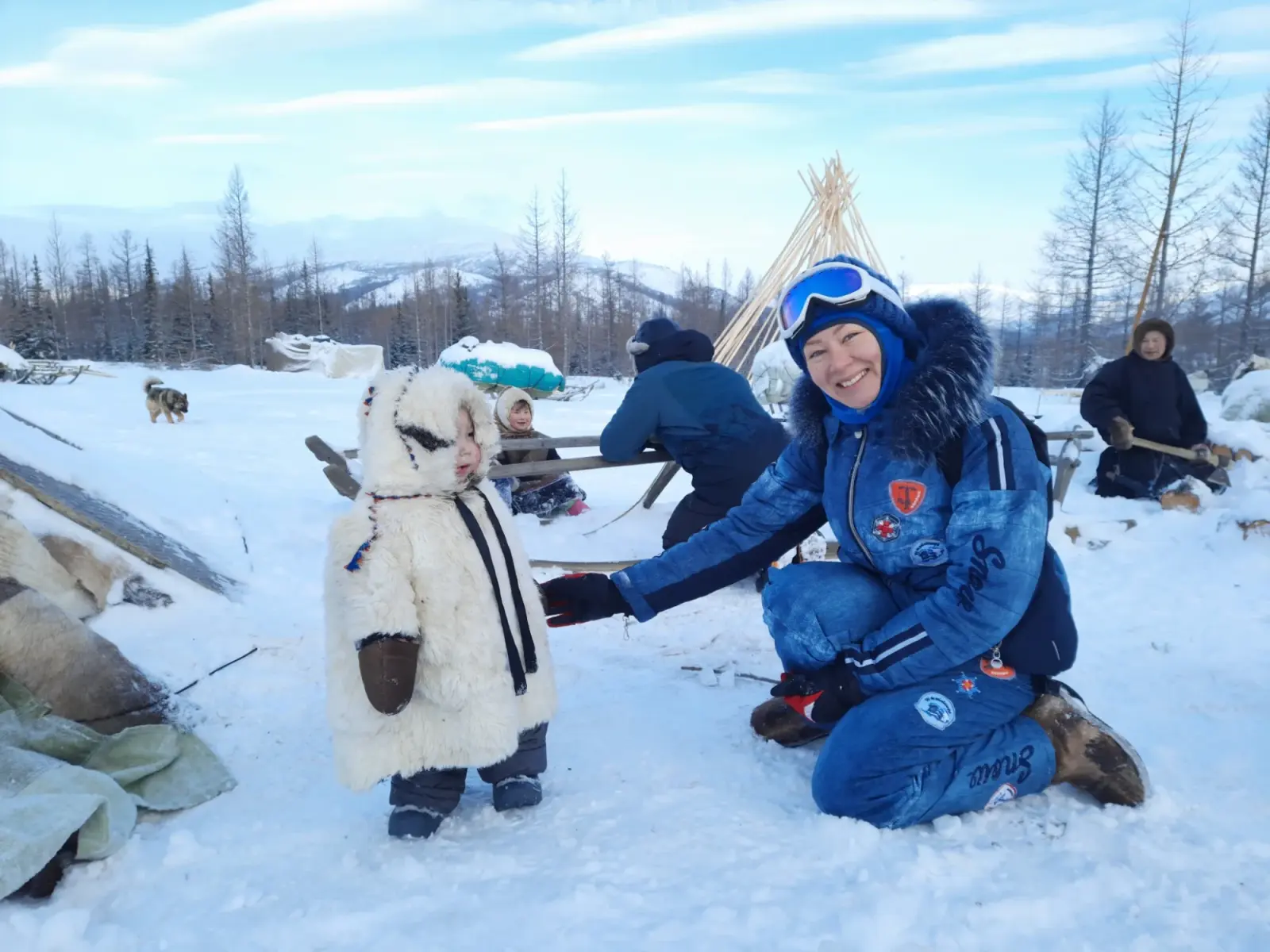 Reiziger met een kind in een witte vacht in de sneeuw van Lapland
