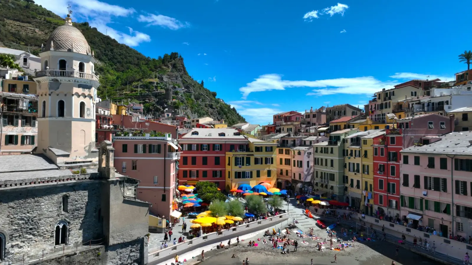 Gekleurde huizen en parasols aan het strandje van Vernazza