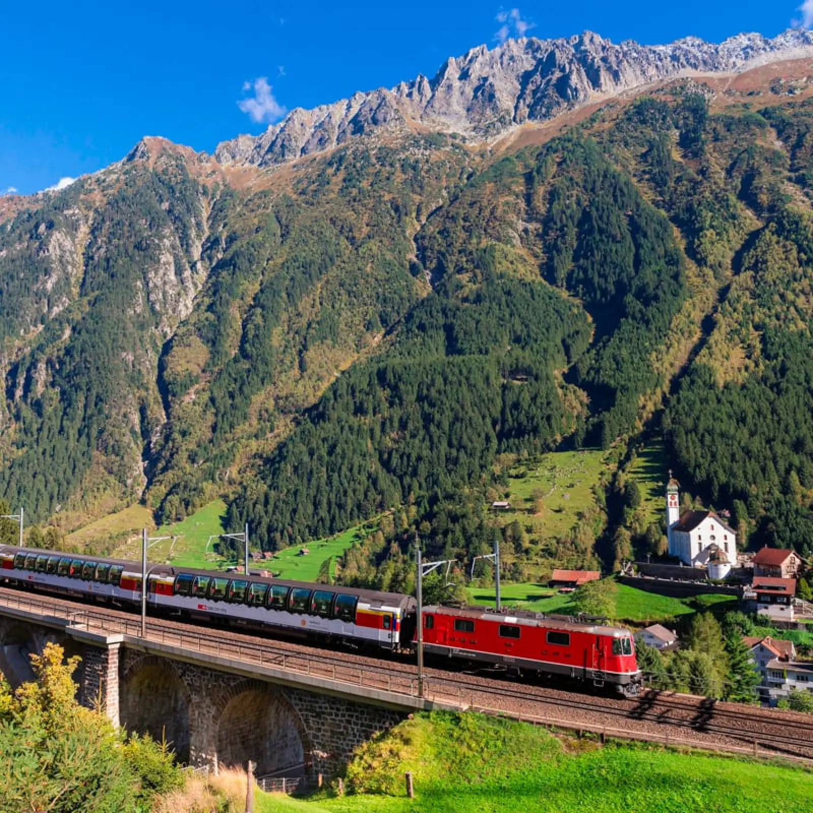 Rode trein over een viaduct tussen de Zwitserse bergen