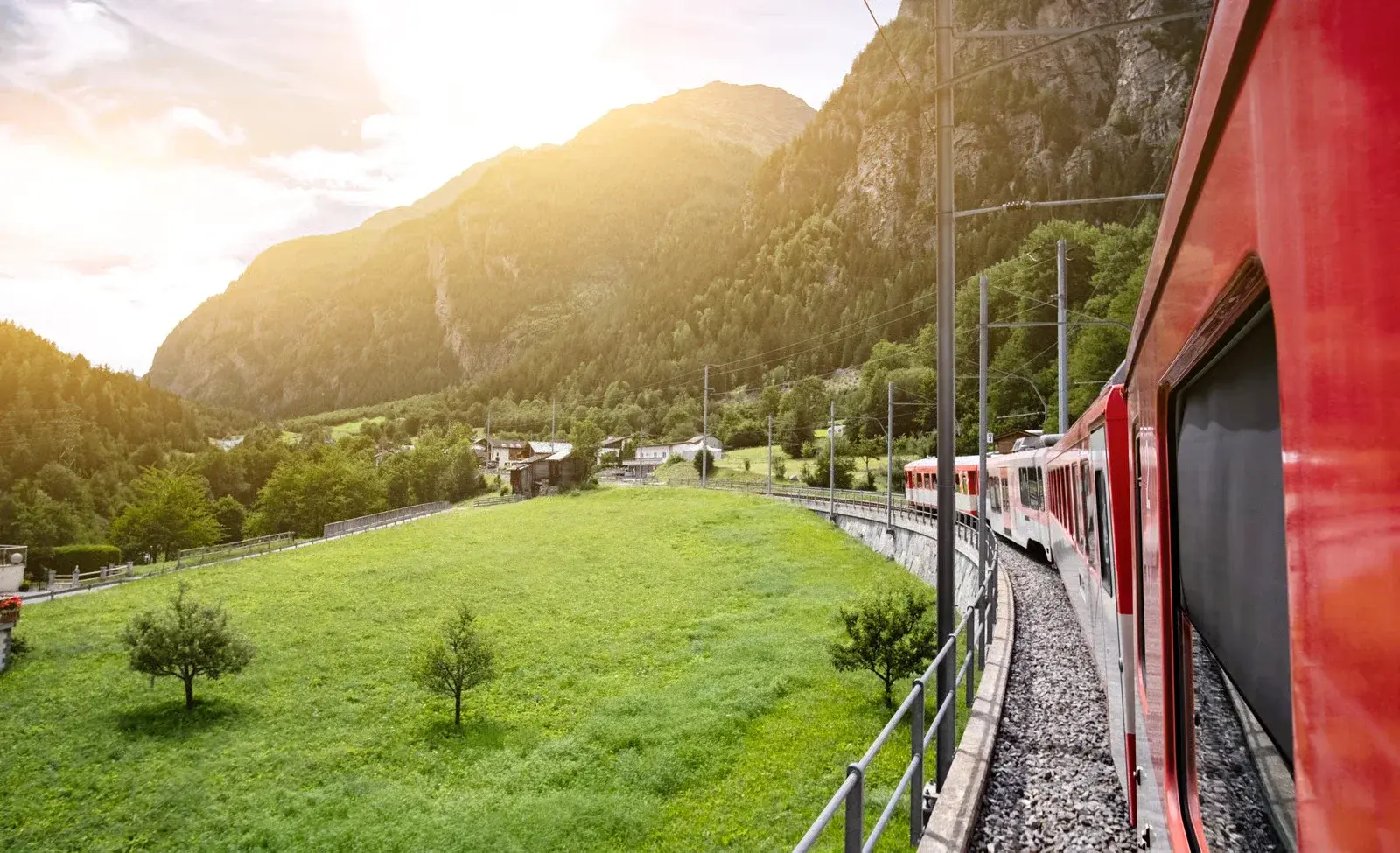 Rode trein door een groen bergdal in Zwitserland